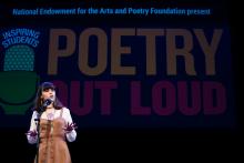 Teenage girl on stage reciting poetry