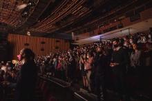 Rows of audience members sitting in a performing arts venue waiting for a performance. 