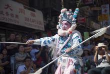 a performer during a parade wears traditional Chinese dress