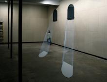 Woman walking through exhibit of wire-created moon rays.
