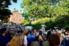 Woman singing in front of large crowd.