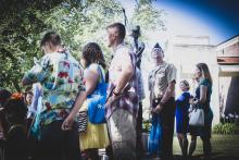 Men, women, and children standing together in an outdoor garden