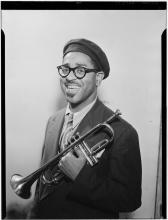 Portrait of man in beret holding a trumpet.