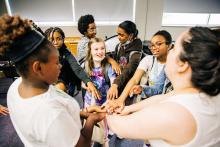 a group of girls stand in a circle with their hands outstretched and joined in the center