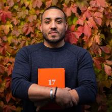 A man clutching a book in his arms.