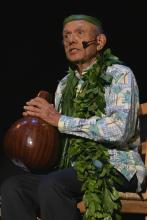 Man holding gourd while sitting in chair 