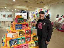 a man stands next to an ofrenda