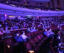 People seated in a theater wearing masks