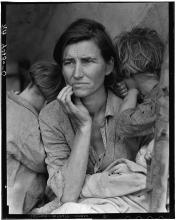 Black and white photo of mother staring off to the side surrounded by her children