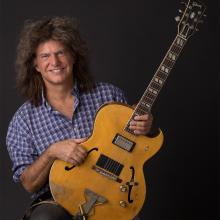Portrait of man holding guitar. 