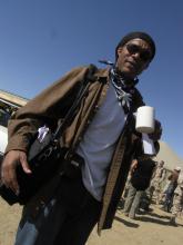 Man wearing sunglasses outside holding coffee cup.