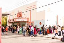 a crowd walks toward a theater