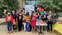 A group of people stand outside holding copies of The House on Mango Street