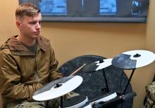 a soldier playing on a drum kit