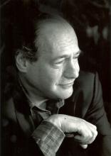 Portrait of white man, balding, wearing a suitcoat and looking to his left. 