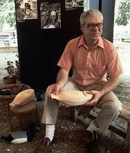 A man holding a wooden decoy.