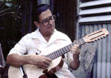 A man playing a Puertorican cuatro.