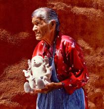 A wman holding a sculture ceramic vasse.
