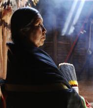 A woman shrouded in a native shawl seen in profile.