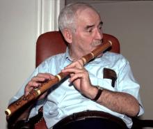 A man playing a wooden flute.