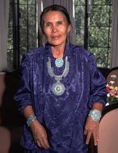 A woman in native dress poses for the camera.