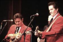 Two men on stage playing their instruments.