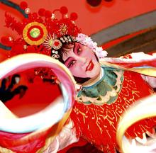 A woman in an elaborate costume strikes a dance pose.