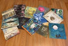 a grouping of several children's books on a wooden floor