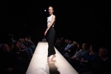 White woman dancing on a stage with audiences surrounding both sides of the stage.