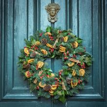 green christmas wreath hanging on green door