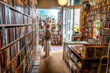 an older woman looking at books in a neighborhood book store