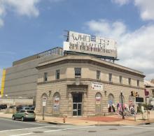 an older building with a billboard that says "Who is Creative Placemaking?"