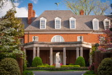 view of mansion with colonnaded entrance and statue and hedges in foreground