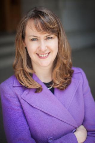 Beth Bienvenu, who is a white woman in a light purple suit