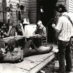Film crew recording an elderly man on his porch