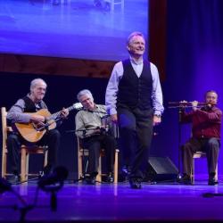 Irish step dancer Kevin doyle dancing onstage in front of a quartet of musicians