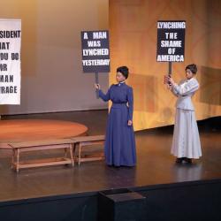 Three actresses portray suffragettes in a scene from a play