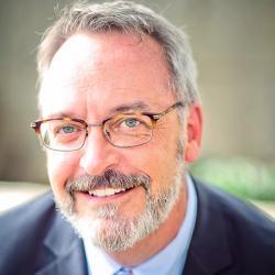 Todd Stein Headshot of a man smiling with glasses and gray hair