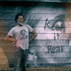 African-American man standing in front of his mural. 