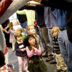 Kids going under a bridge of adult arms.