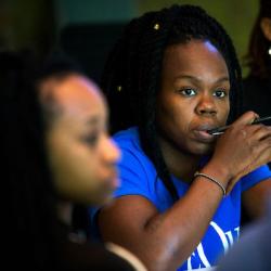 three African-American woman theater artists watching a performance that is out of the frame