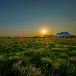 White tents at sunsets in middle of Kansas grassland prairie