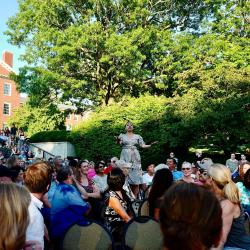 Woman singing in front of large crowd.