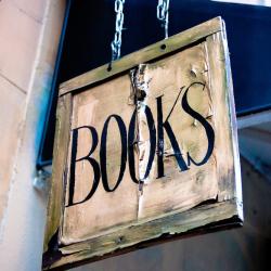 weathered hanging sign that says books in capital letters