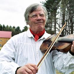 Man playing a fiddle outdoors.