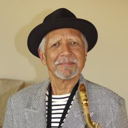 Man in hat holding saxophone.