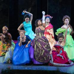 6 actresses in various costumes onstage during a scene from Cinderella