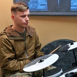 a soldier playing on a drum kit