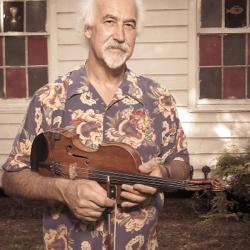 A man poses holding a mandolin.