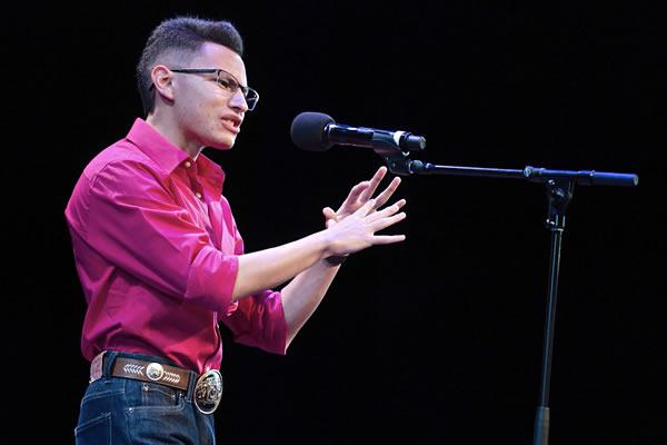 Student at the microphone reciting a poem